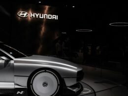 Ein weißes Auto steht geparkt in einem hell beleuchteten Ausstellungsraum und zeigt modernes Karosseriedesign.