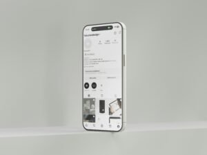 Ein weißes Mobiltelefon hängt mittig an einer hellen Wand, minimalistisches Motiv, Technik-Symbolbild