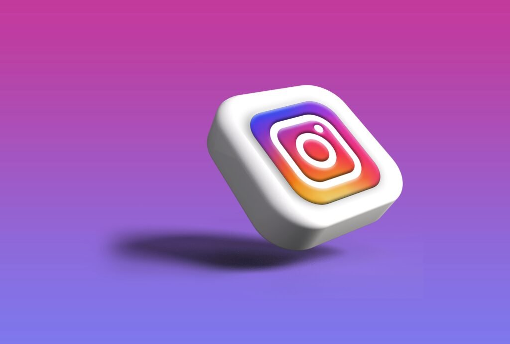 Weißer Würfel mit farbigem Instagram Logo auf der Vorderseite, fotografiert auf neutralem Hintergrund.