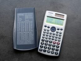 Ein moderner wissenschaftlicher Taschenrechner mit offenem Deckel liegt auf einem Tisch, ideal für mathematische Berechnungen.