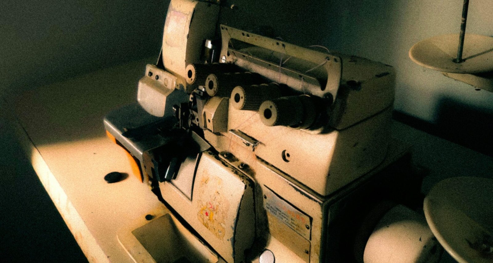 Eine antike Nähmaschine steht auf einem Holztisch und verdeutlicht historische Handarbeitstechniken.