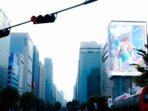 Eine Ampel hängt hoch über einer mehrspurigen Stadtstraße und steuert den fließenden Verkehr in einer urbanen Umgebung.
