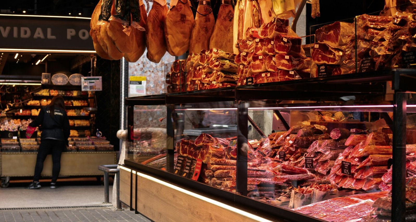 Mehrere Fleischstücke hängen ordentlich an Haken in einem Geschäft, aufgenommen zur Illustration traditioneller Präsentation.