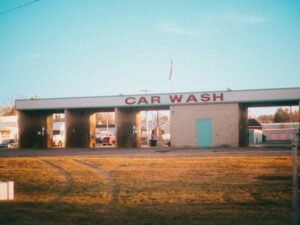 Eine Autowaschanlage mit geparkten Autos davor, aufgenommen am Tag; geeignet für Themen rund um Fahrzeugpflege und Wartung.