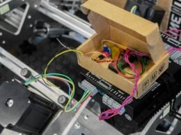 Ein offener Kasten mit verschiedenen Drähten und Kabeln, der detaillierte Einblicke in die interne Verkabelung bietet.