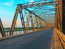 Eine moderne Brücke mit einem ausgebauten Gehweg, aufgenommen aus seitlicher Perspektive; zeigt Konstruktion und Wegführung.