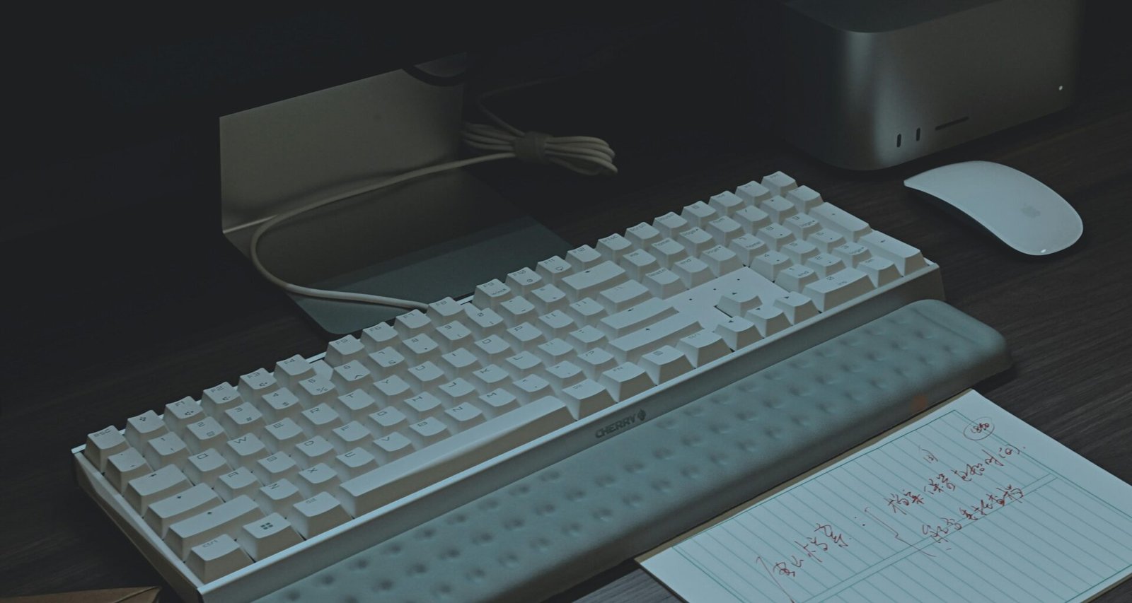 Eine Computer-Tastatur liegt auf einem hellen Holzschreibtisch, Nahaufnahme mit klar sichtbaren Tasten und strukturierter Tischoberfläche.