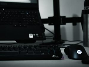 Computer-Tastatur, Maus und Laptop auf einem Schreibtisch als moderner Arbeitsplatz für digitale Aufgaben