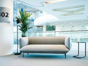 Ein modernes Wohnzimmer mit einem Couch und einem Tisch, platziert in einem schlichten, hellen Raum