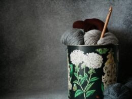 Nahaufnahme einer Garnbüchse mit einem aufgerollten Wollknäuel, ideal zur Verdeutlichung von Handarbeit oder DIY-Themen