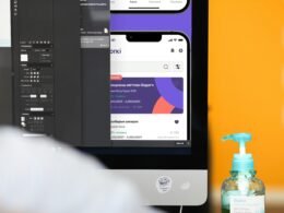 Flasche mit Handdesinfektionsmittel steht neben einem Computerbildschirm auf einem Schreibtisch im Büro