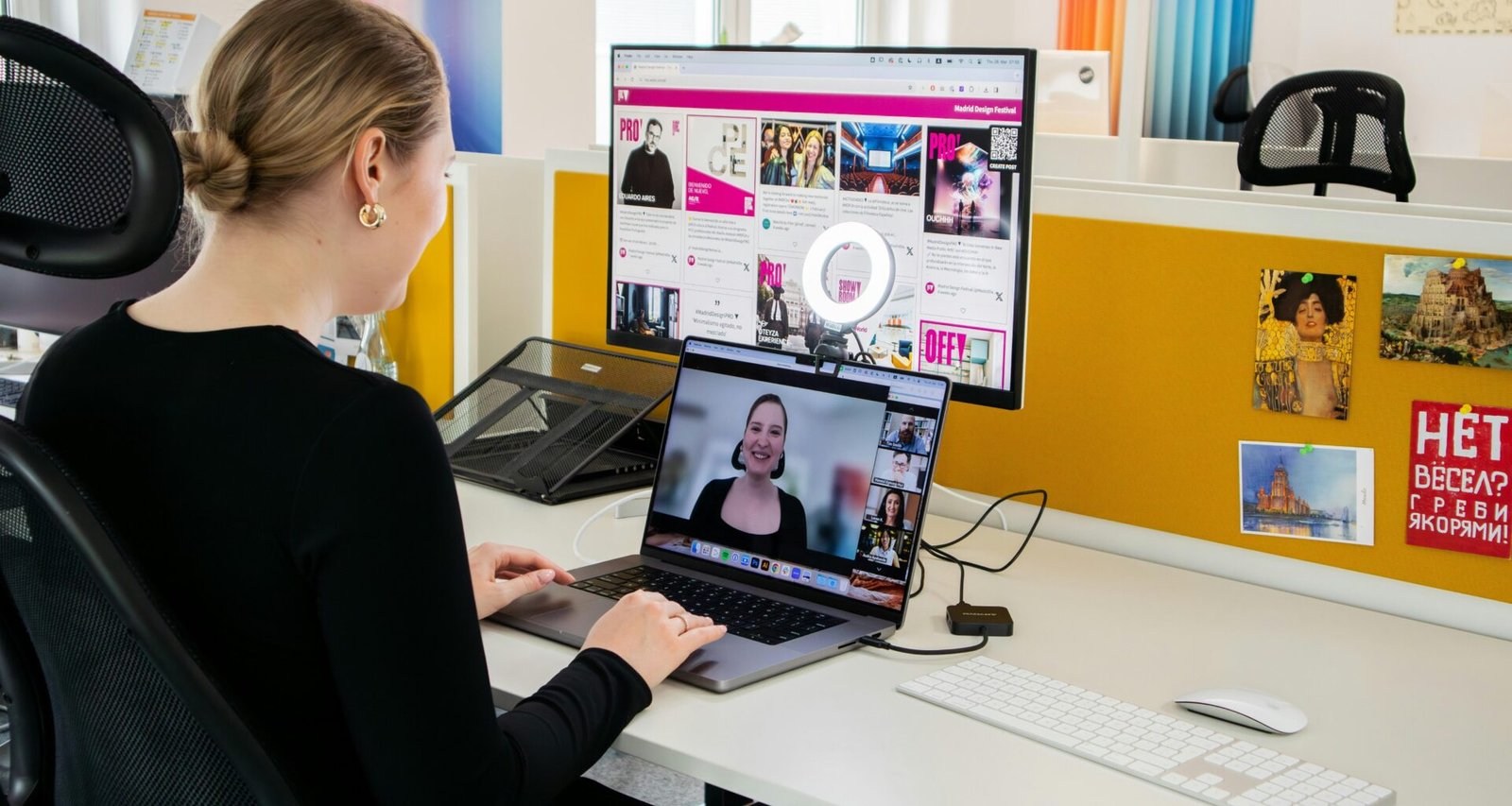 Eine Frau sitzt an einem Schreibtisch und arbeitet konzentriert an einem Laptop in einem hellen Büro.