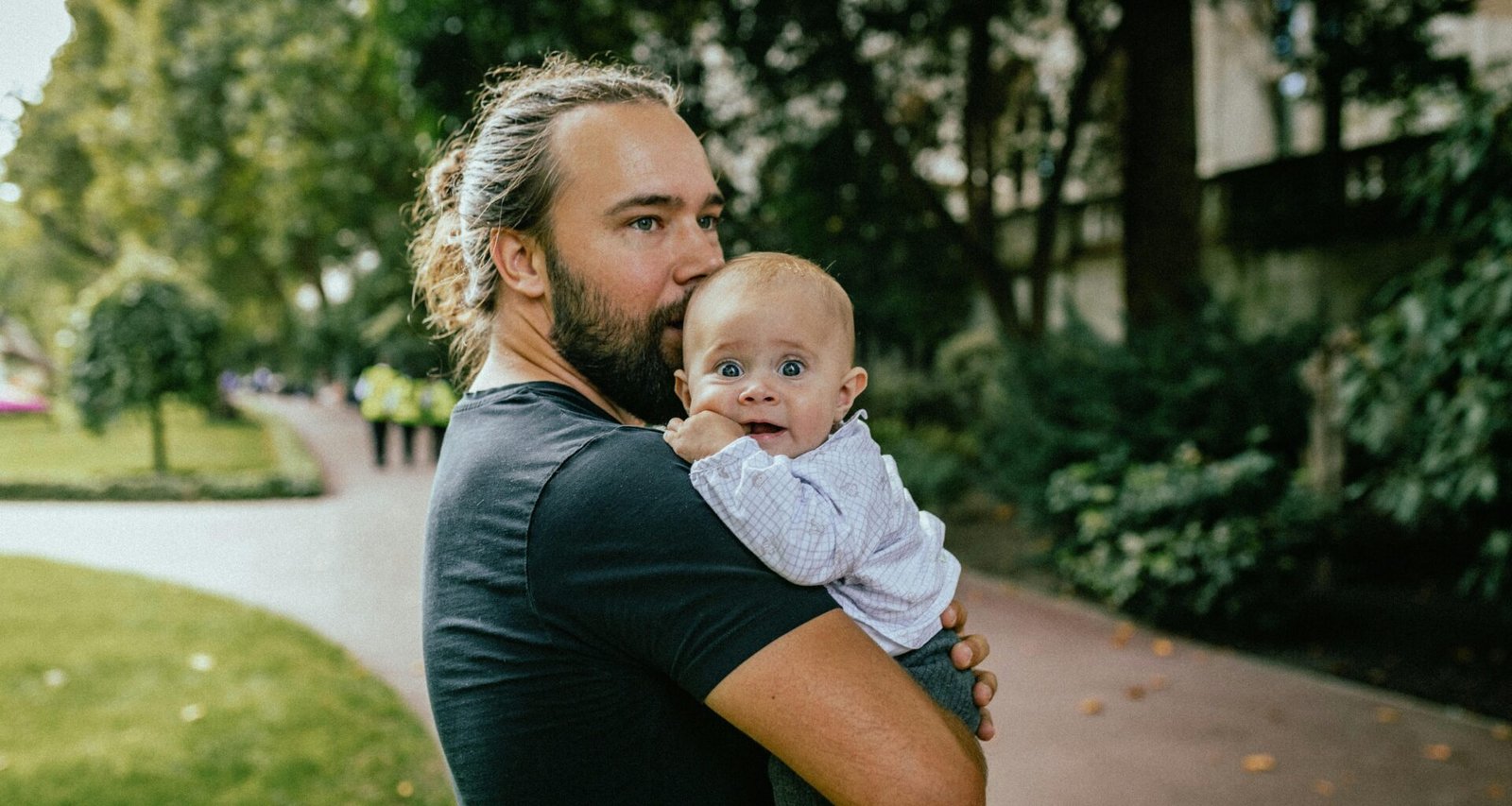 Eine Frau steht und hält ein Baby im Arm. Das Baby blickt zur Frau, beide sind im Innenraum zu sehen.