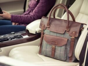 Eine Frau sitzt auf dem Fahrersitz eines Autos und hält ein Smartphone in der Hand, modernes Kommunikationsmittel im Einsatz.