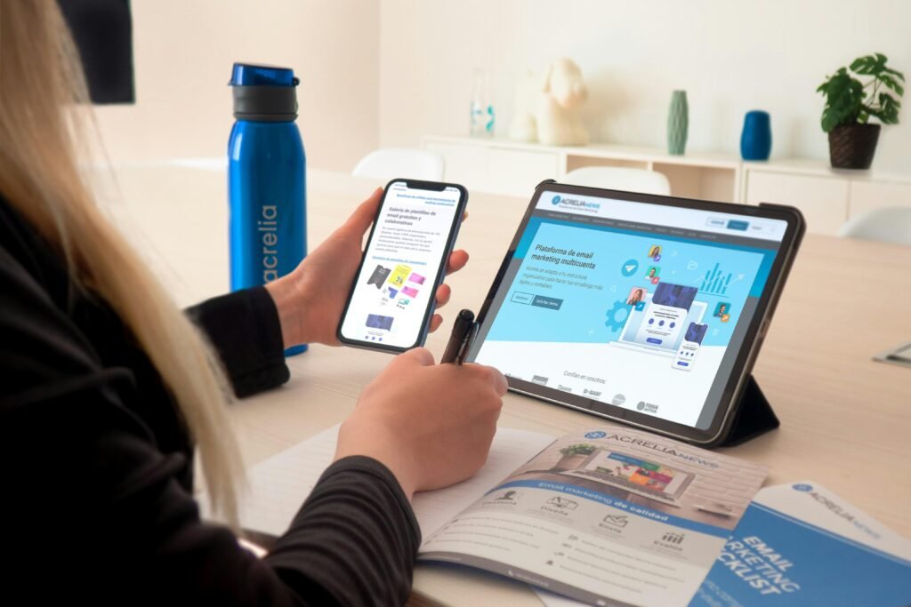 Eine Frau sitzt an einem Tisch in einem modernen Raum und verwendet ein Tablet zur digitalen Arbeit oder Recherche.