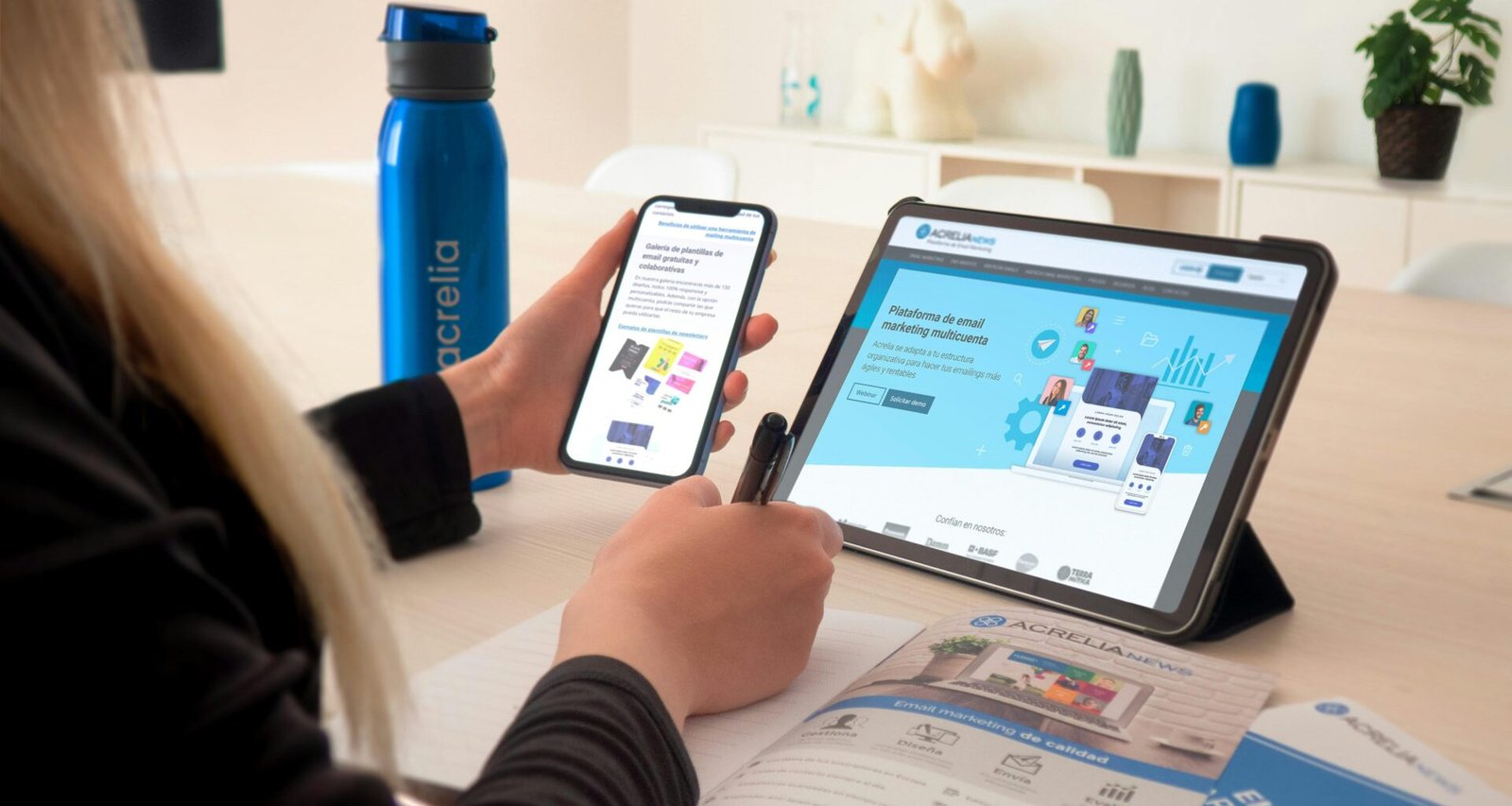 Eine Frau sitzt an einem Tisch in einem modernen Raum und verwendet ein Tablet zur digitalen Arbeit oder Recherche.