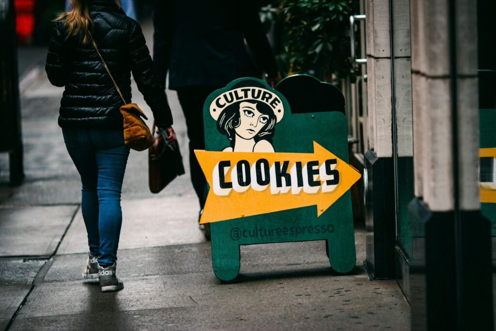 Eine Frau läuft auf dem Bürgersteig an einem großen Schild vorbei, das für Cookies wirbt.