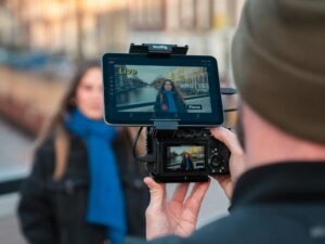 Frau mit blauem Schal wird im Freien gefilmt, Hintergründe unscharf, Fokus auf Outdoor-Setting