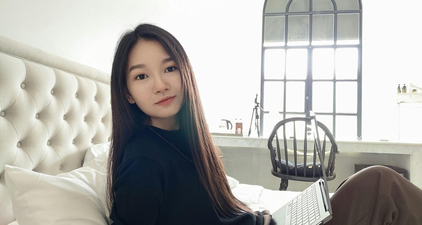 Eine Frau sitzt entspannt auf einem Sofa mit Laptop, ideal für Themen rund um Homeoffice und Produktivität