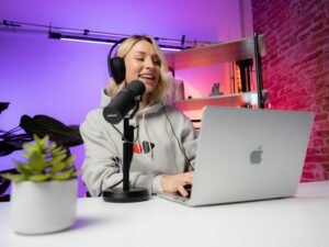 Frau sitzt an einem Schreibtisch mit Laptop und arbeitet im Homeoffice. Moderne Arbeitsumgebung mit Fokus auf Technologie.