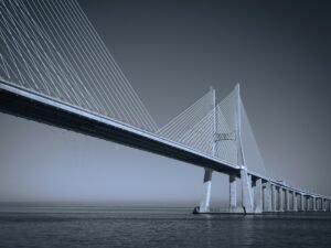 Große Brücke aus Stahl und Beton überspannt ein weitläufiges Gewässer bei Tageslicht