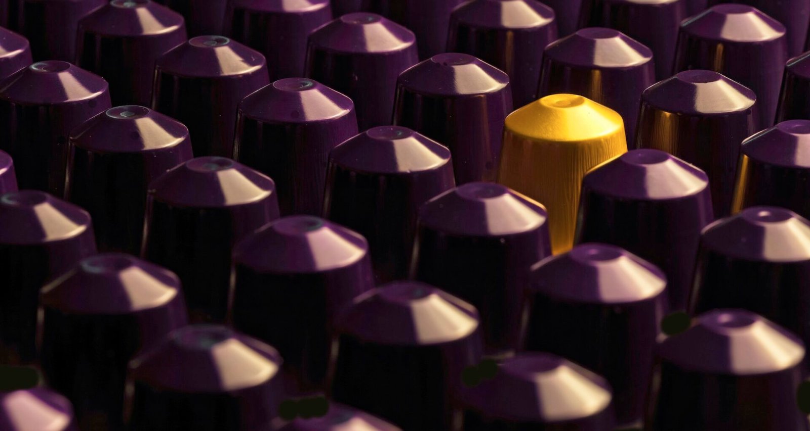 Nahaufnahme vieler lila und gelber Patronenkappen, die in großer Menge angeordnet sind