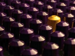 Nahaufnahme vieler lila und gelber Patronenkappen, die in großer Menge angeordnet sind