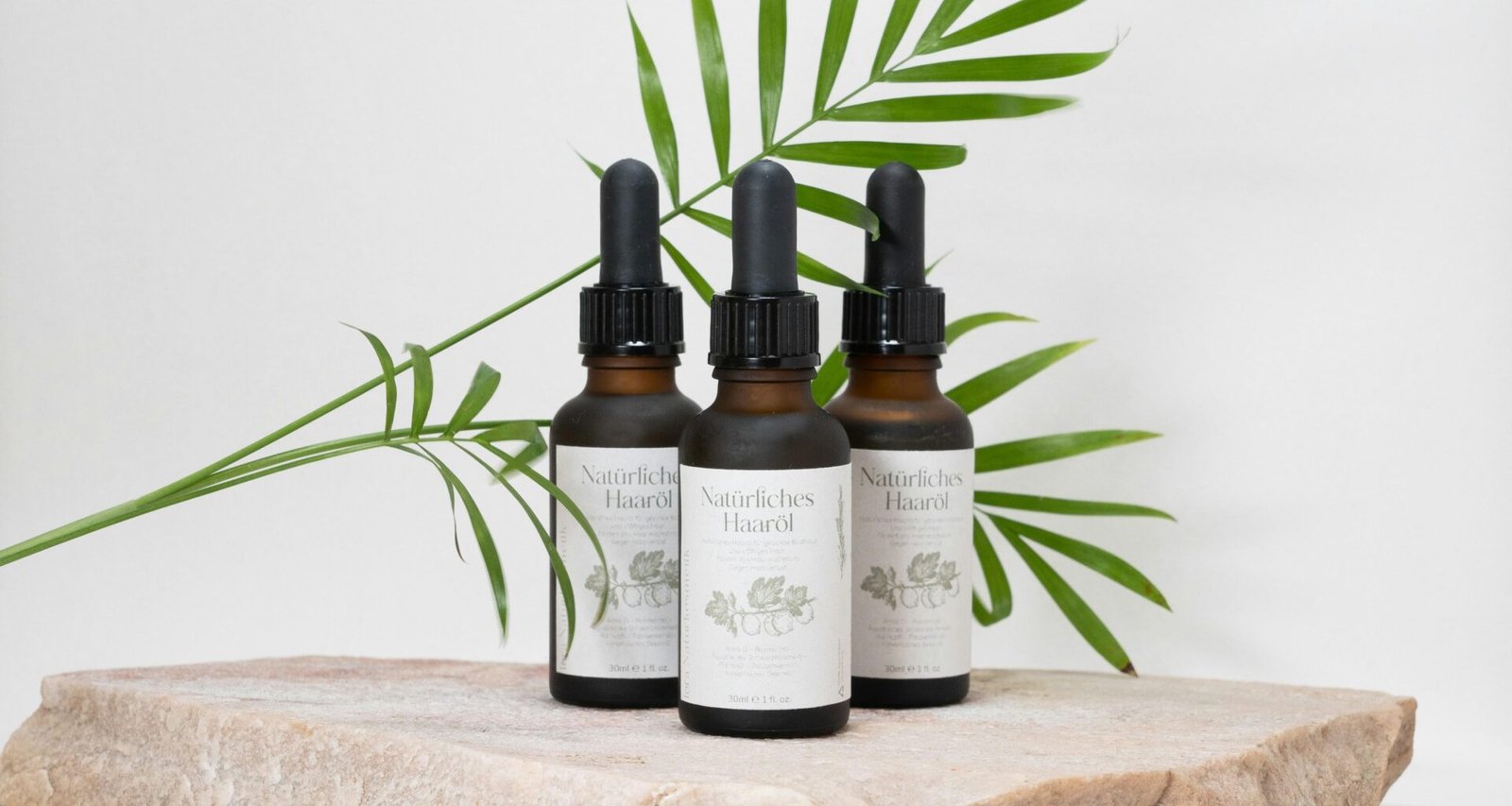 Mehrere Flaschen mit unterschiedlich gefärbten Flüssigkeiten stehen nebeneinander auf einem Tisch.