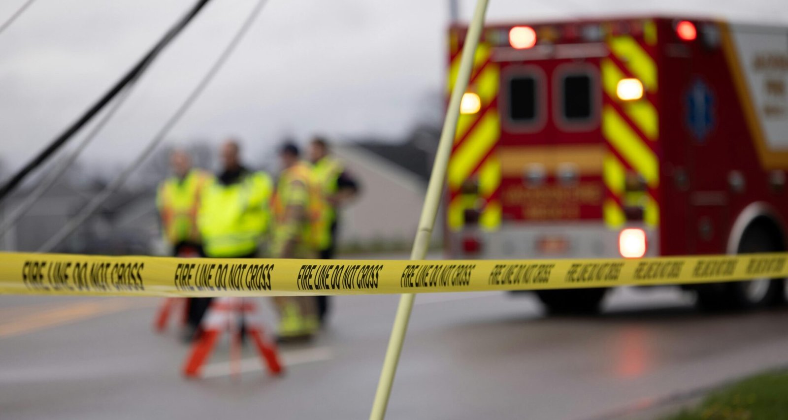 Eine Gruppe von Menschen steht in Arbeitskleidung neben einem roten Feuerwehrwagen im Freien.