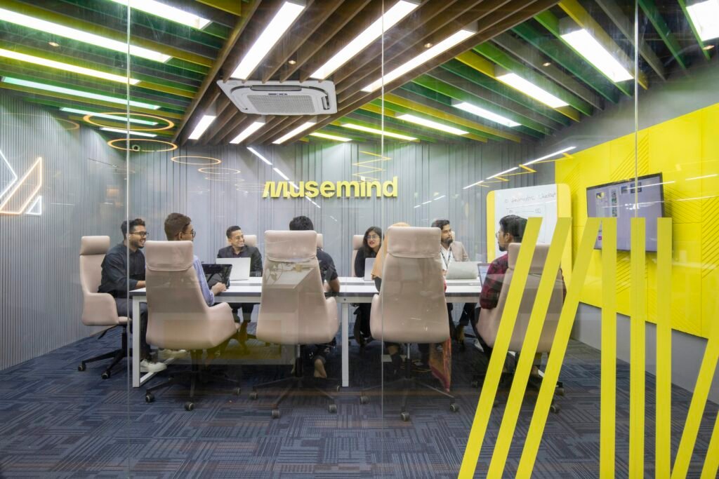 Mehrere Personen sitzen gemeinsam an einem Tisch und besprechen ein Projekt in moderner Arbeitsumgebung.