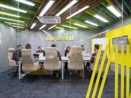 Mehrere Personen sitzen gemeinsam an einem Tisch und arbeiten an einem Projekt im modernen Büro