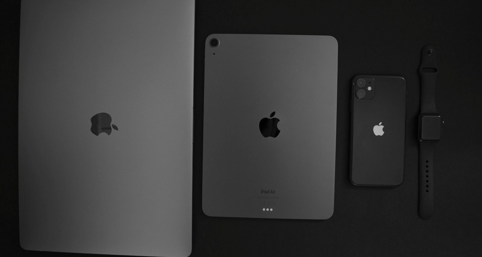 Verschiedene moderne Smartphones liegen nebeneinander auf einer Tischoberfläche und verdeutlichen die Vielfalt mobiler Endgeräte.
