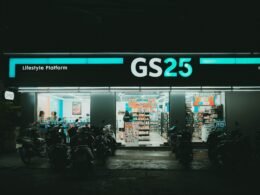 Mehrere Motorräder sind vor einem Laden geparkt, im Vordergrund mit geschäftigem Straßenszene