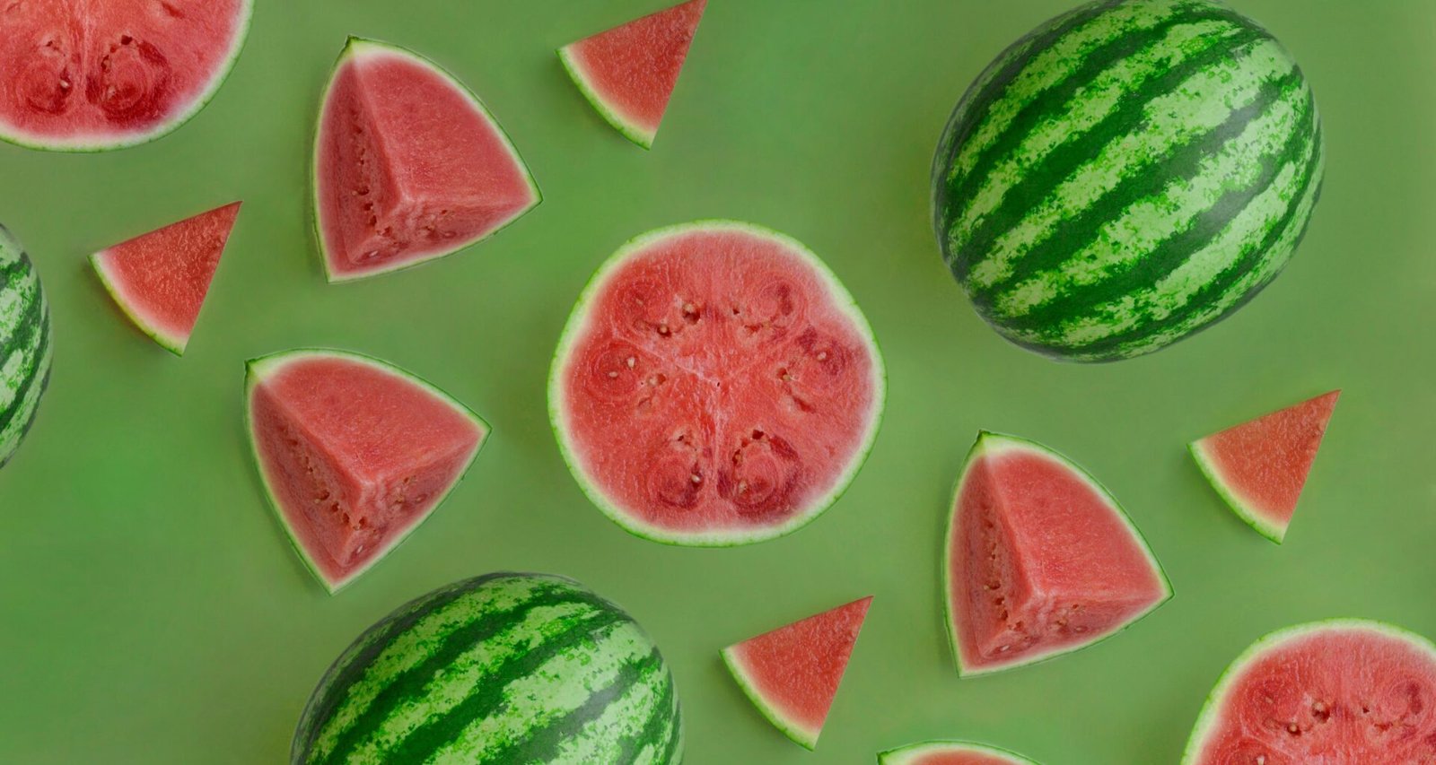 Mehrere Wassermelonen mit grüner, gesprenkelter Schale liegen eng beieinander und bilden eine natürliche Gruppe.