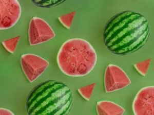 Mehrere Wassermelonen mit grüner, gesprenkelter Schale liegen eng beieinander und bilden eine natürliche Gruppe.