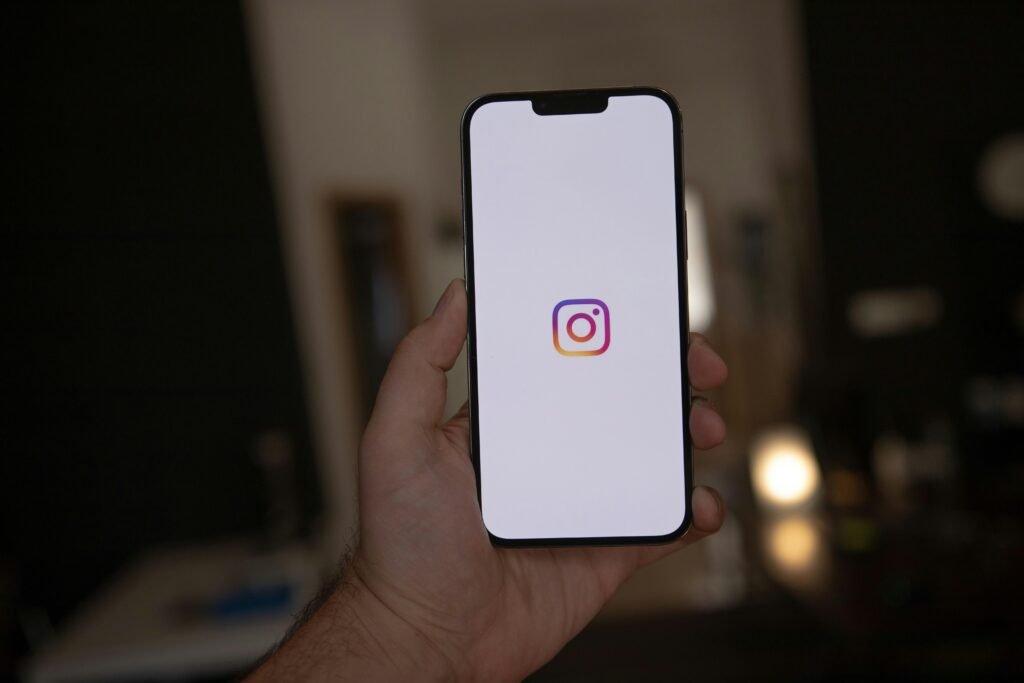 Eine Hand hält ein weißes Smartphone, ideal als Symbolbild für mobile Technologie und digitale Kommunikation.