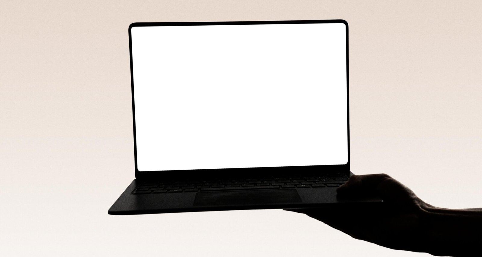 Hand hält einen Laptop mit leerem Bildschirm, zentrales Motiv für digitale Themen und Präsentationen