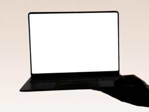 Hand hält einen Laptop mit leerem Bildschirm, zentrales Motiv für digitale Themen und Präsentationen