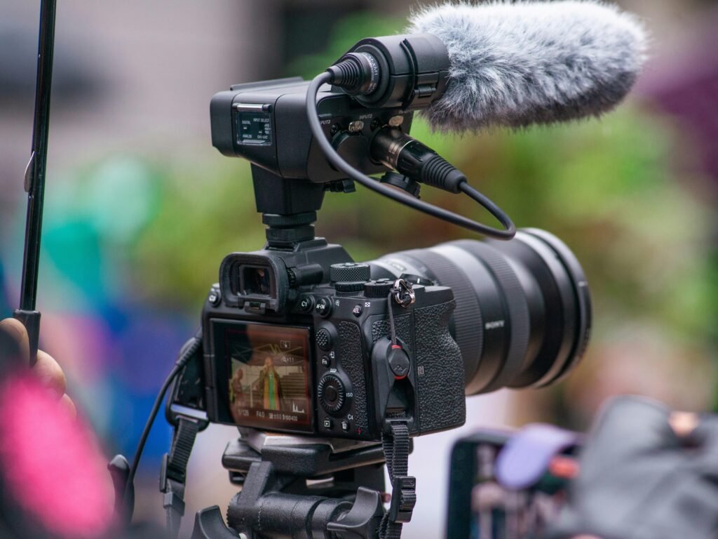 Moderne Kamera mit angebrachtem Mikrofon für professionelle Audio- und Videoaufnahmen auf einem Tisch