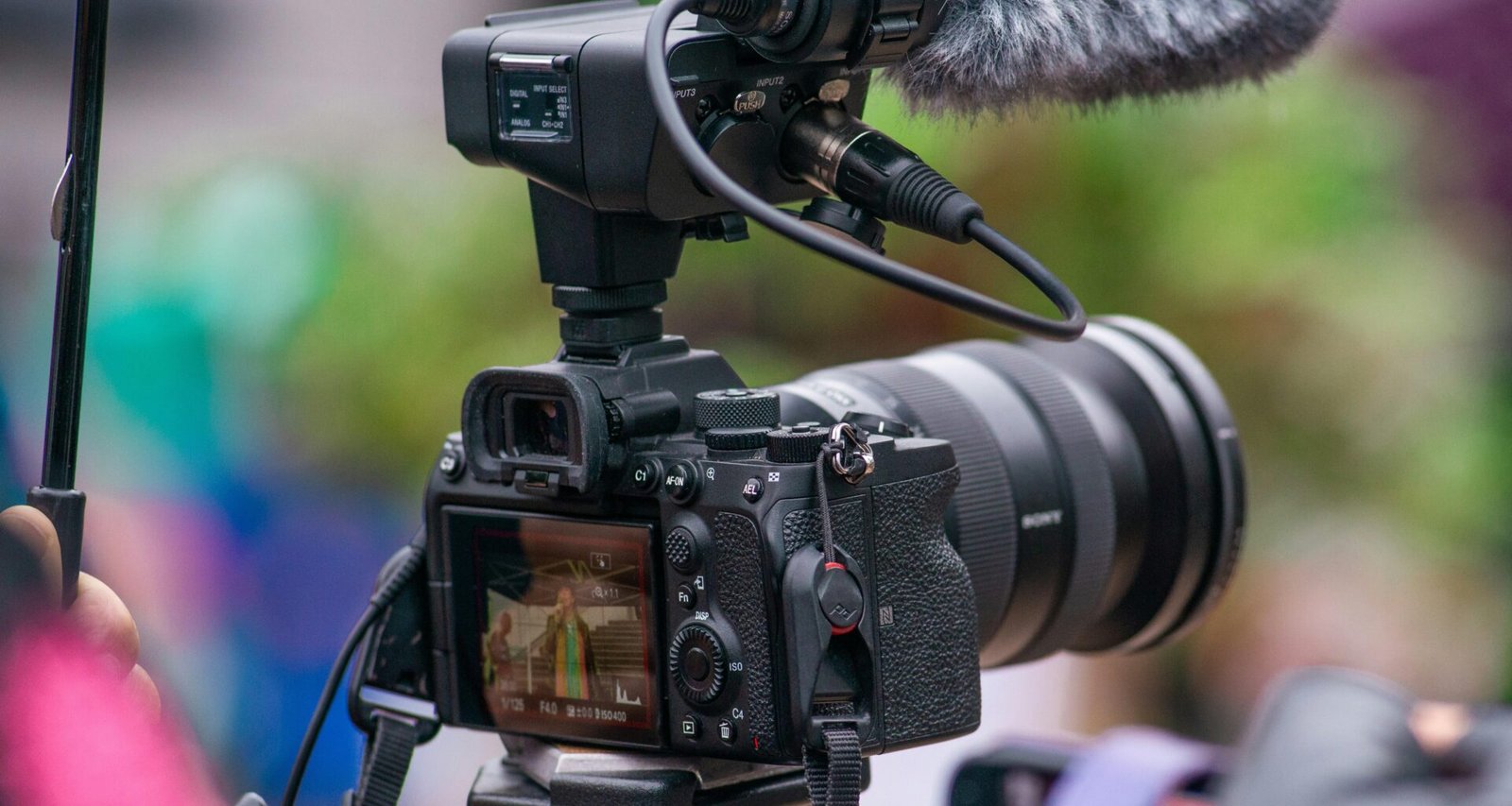 Moderne Kamera mit angebrachtem Mikrofon für professionelle Audio- und Videoaufnahmen auf einem Tisch