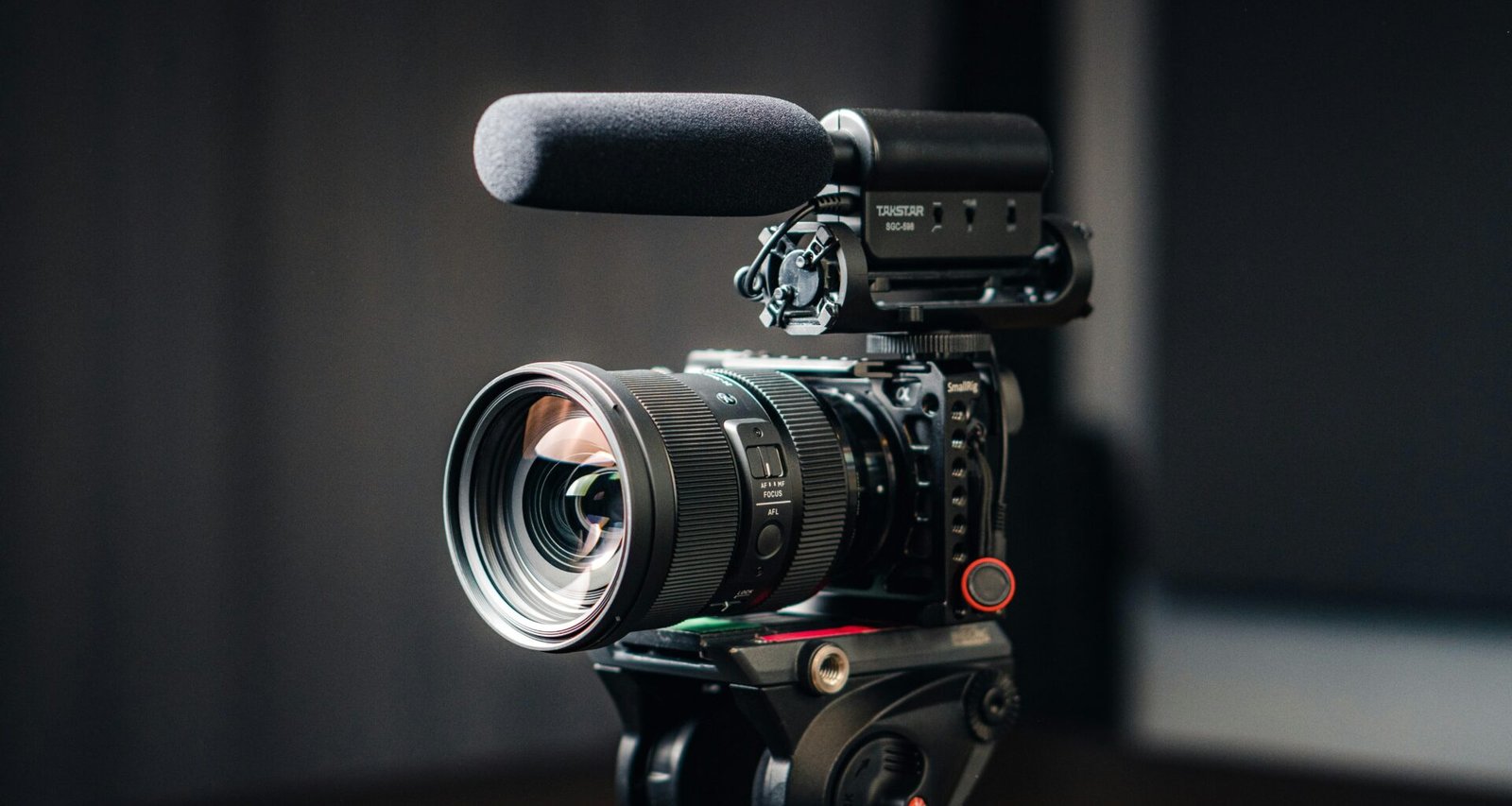 Nahaufnahme einer modernen Kamera mit montiertem Objektiv auf hellem Hintergrund, Fokus auf das Kameraobjektiv