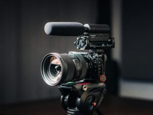 Nahaufnahme einer modernen Kamera mit montiertem Objektiv auf hellem Hintergrund, Fokus auf das Kameraobjektiv