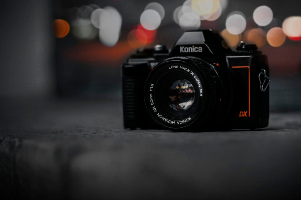 Kamera auf einem Tisch mit Hintergrund aus verschwommenen Lichtern, aufgenommen als modernes Fotomotiv in Innenräumen