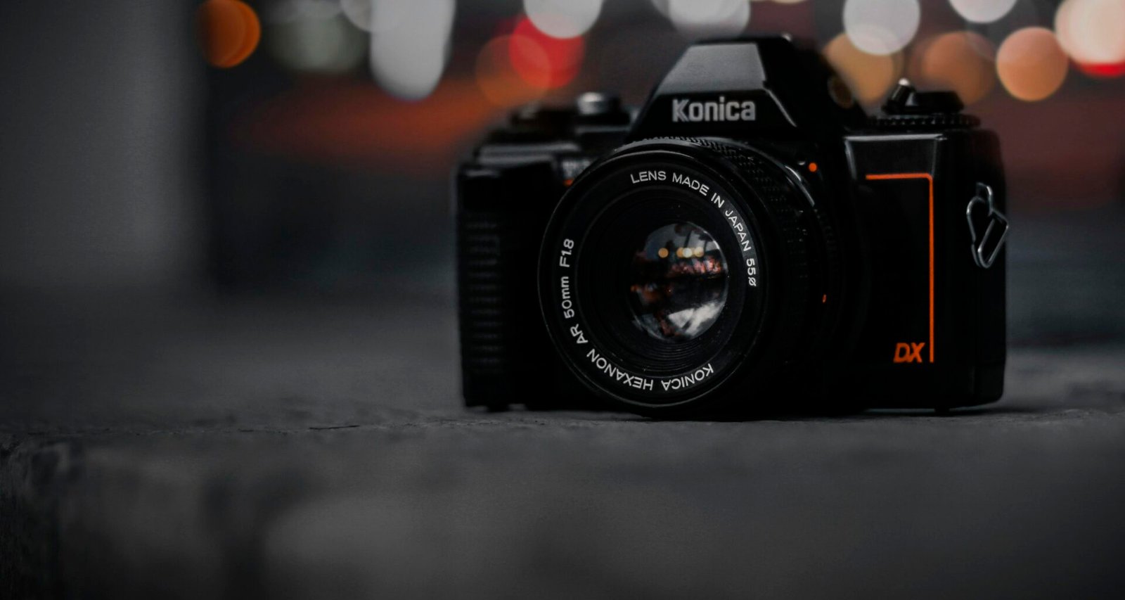 Kamera auf einem Tisch mit Hintergrund aus verschwommenen Lichtern, aufgenommen als modernes Fotomotiv in Innenräumen