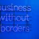 Neon-Schild mit der Aufschrift 'Business without borders' an einer dunklen Wand, Symbol für globale Unternehmensstrategien