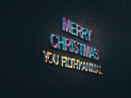 Leuchtendes Neon-Schild mit dem Schriftzug „Merry Christmas You Filthy Animal“ vor dunklem Hintergrund