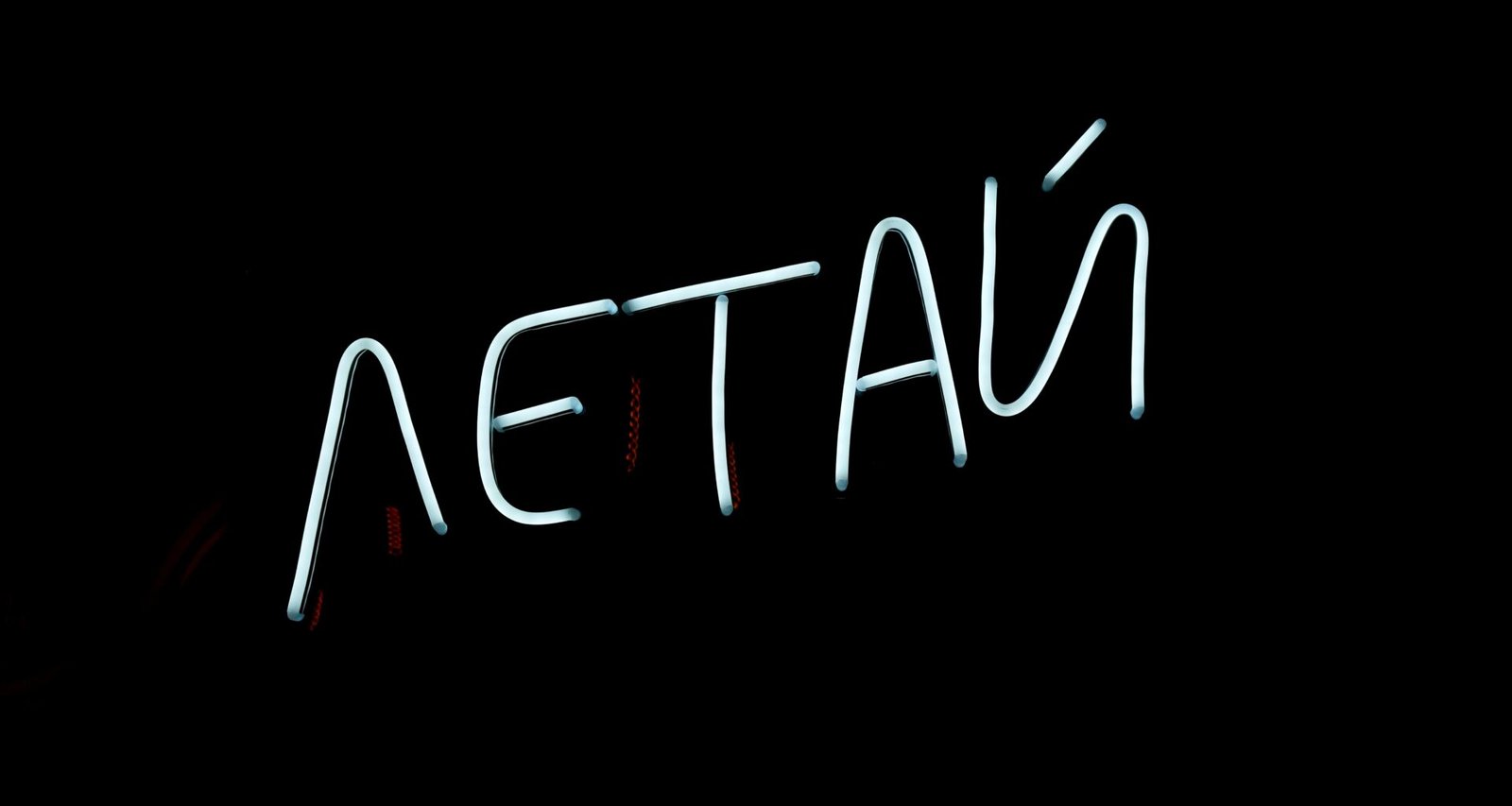 Leuchtender Neon-Schriftzug mit dem Wort 'atetau' auf schwarzem Hintergrund als Artikelbild