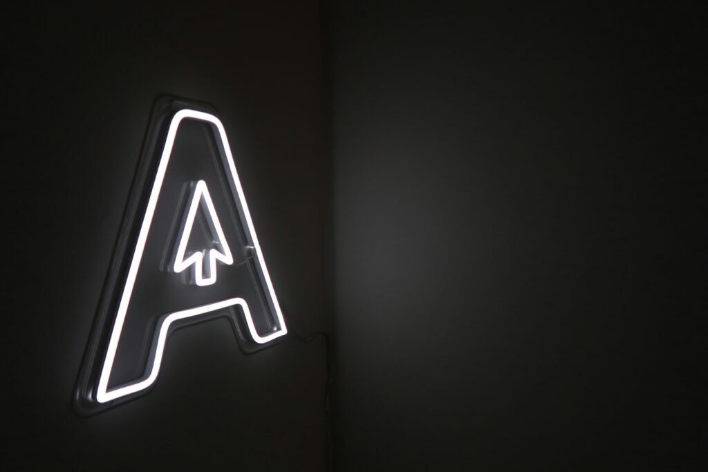 Leuchtender Neon-Schriftzug mit integriertem Pfeil auf dunklem Hintergrund, modernes Element für Online- und Technologiethemen