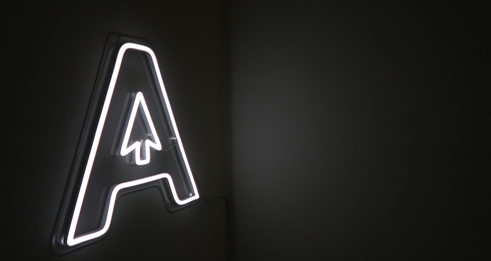 Leuchtender Neon-Schriftzug mit integriertem Pfeil auf dunklem Hintergrund, modernes Element für Online- und Technologiethemen