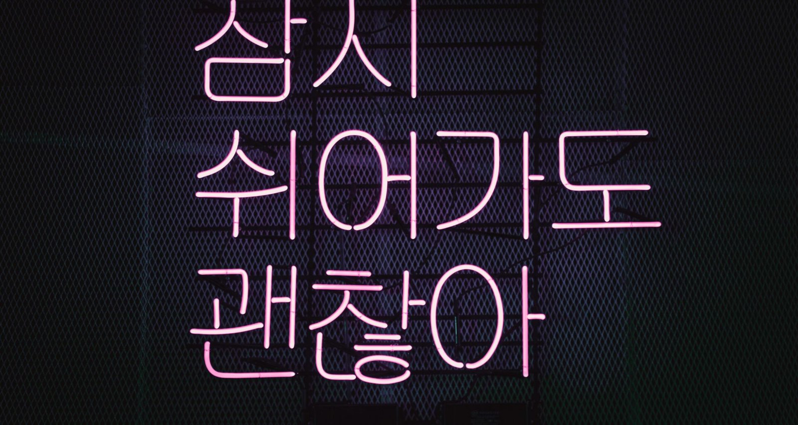 Leuchtendes Neon-Schild mit pinkem Schriftzug vor dunklem Hintergrund als modernes Design-Element